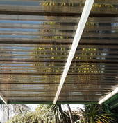 Carport with see through bronze tint polycarb clear sheeting.
