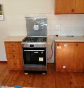 Gas stove with cylinder in cupboard.