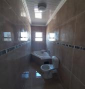 A modern designed Bathroom.Tiled walls and floor. With modern installed ceiling design