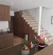 Kitchen in Mono-coat grey finish with wood slats on doors and stairs