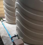 Water tanks on concrete slabs with pumps and filters.