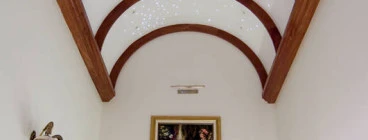 barrel arched ceiling with southern cross lights in ceiling over the art gallery leading to the bedrroms